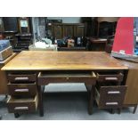 A wooden office desk with central drawer and fligh