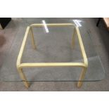 A square glass topped coffee table, small chip to