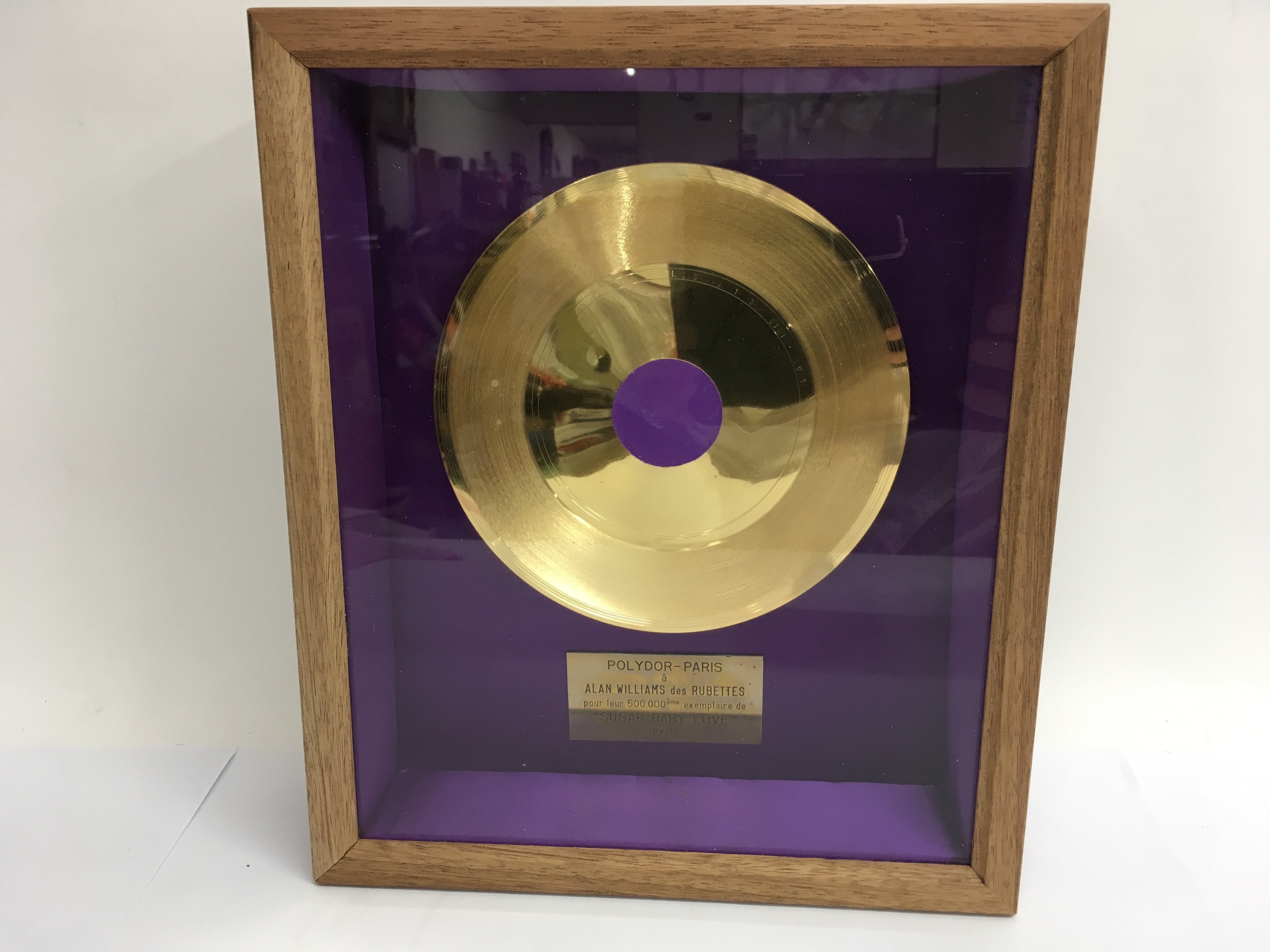 A framed and glazed gold disc for sales of over 50
