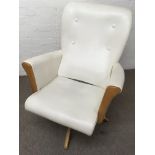 A modern design swivel chair with light wood frame and cream faux leather upholstery