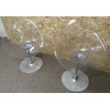 A pair of Kartell plexiglas tub chairs on adjustab