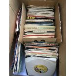 A box containing a collection of 7 inch singles by