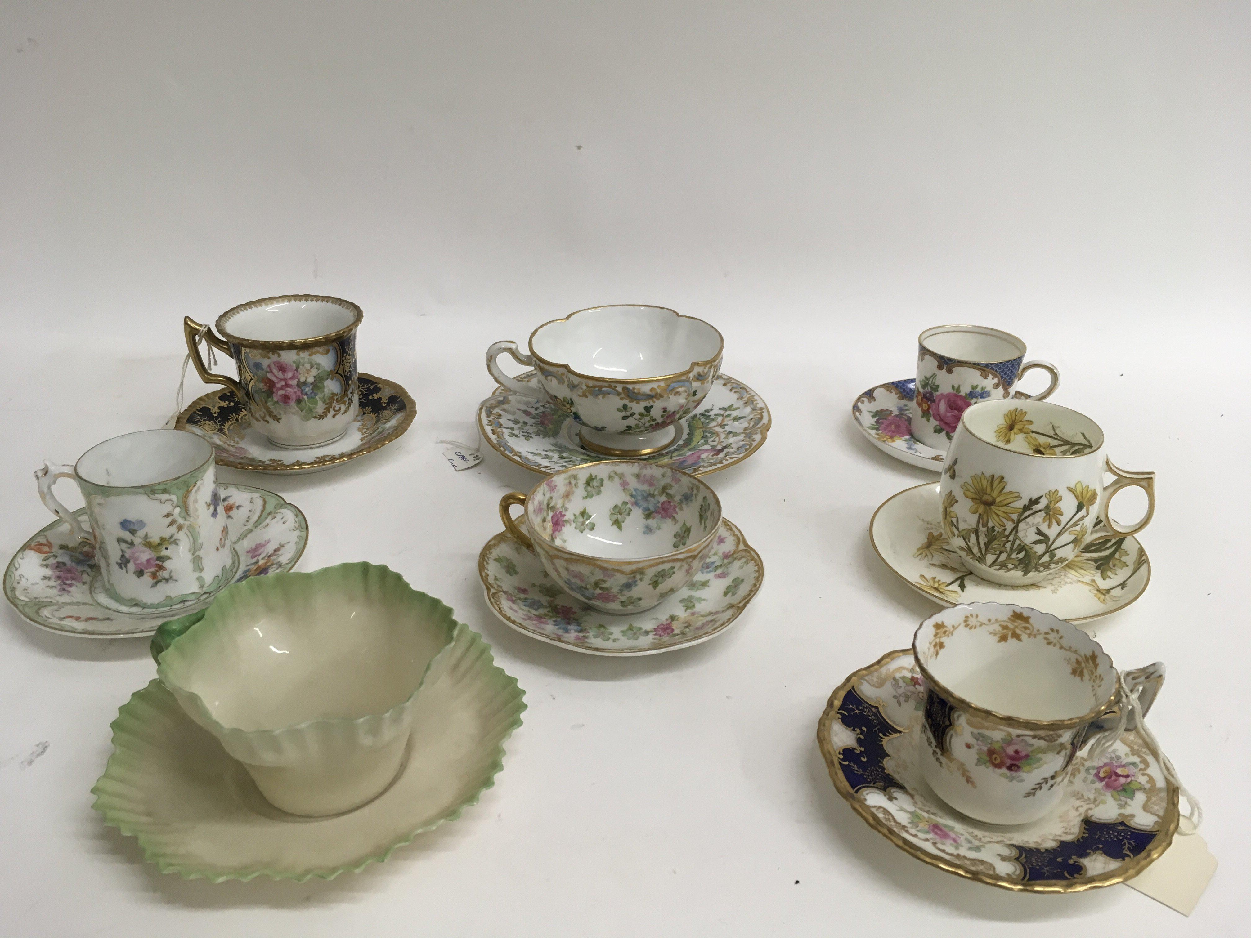 A collection of eight decorative painted cabinet cups and saucers including Coalport and Limoges