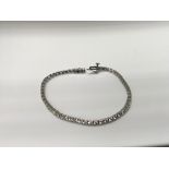 A 9 ct white gold line bracelet inset with 55 smal