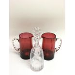 A pair of cranberry glass jugs with twist handles