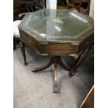 A George III Style revolving campaign type table with brass inset corners and handles.