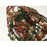 A collection of polished stone necklaces including