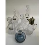 Four cut glass decanters, a blue glass example and