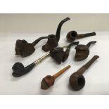A collection of smoker's pipes with carved bowls (
