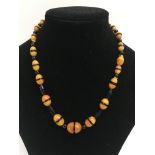 An Art Deco amber and black bead necklace of gradu