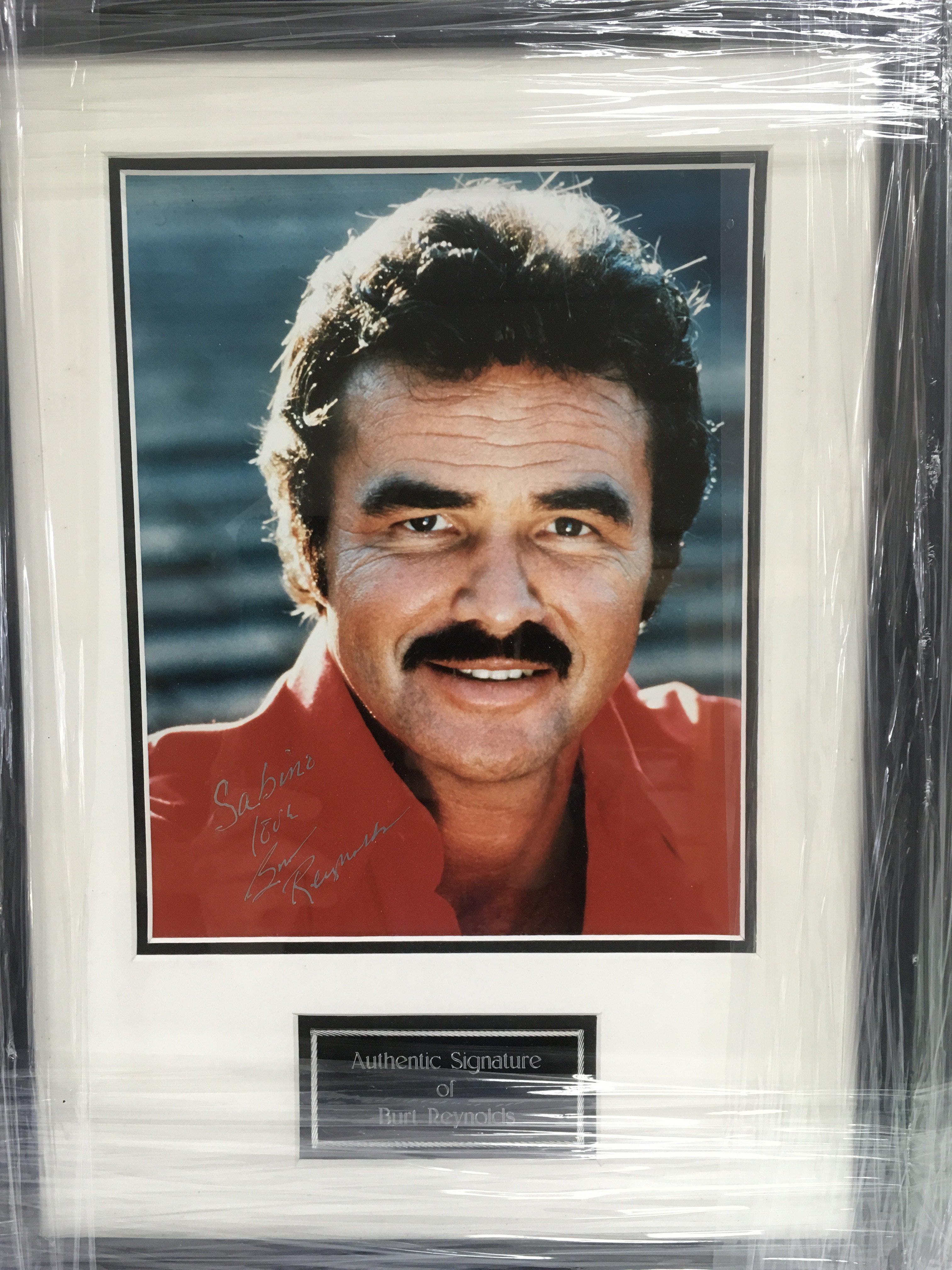 A framed and glazed photograph of Burt Reynolds wi