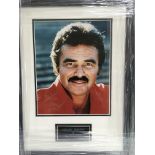 A framed and glazed photograph of Burt Reynolds wi