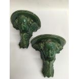 A pair of green glazed cherub wall brackets.Approx