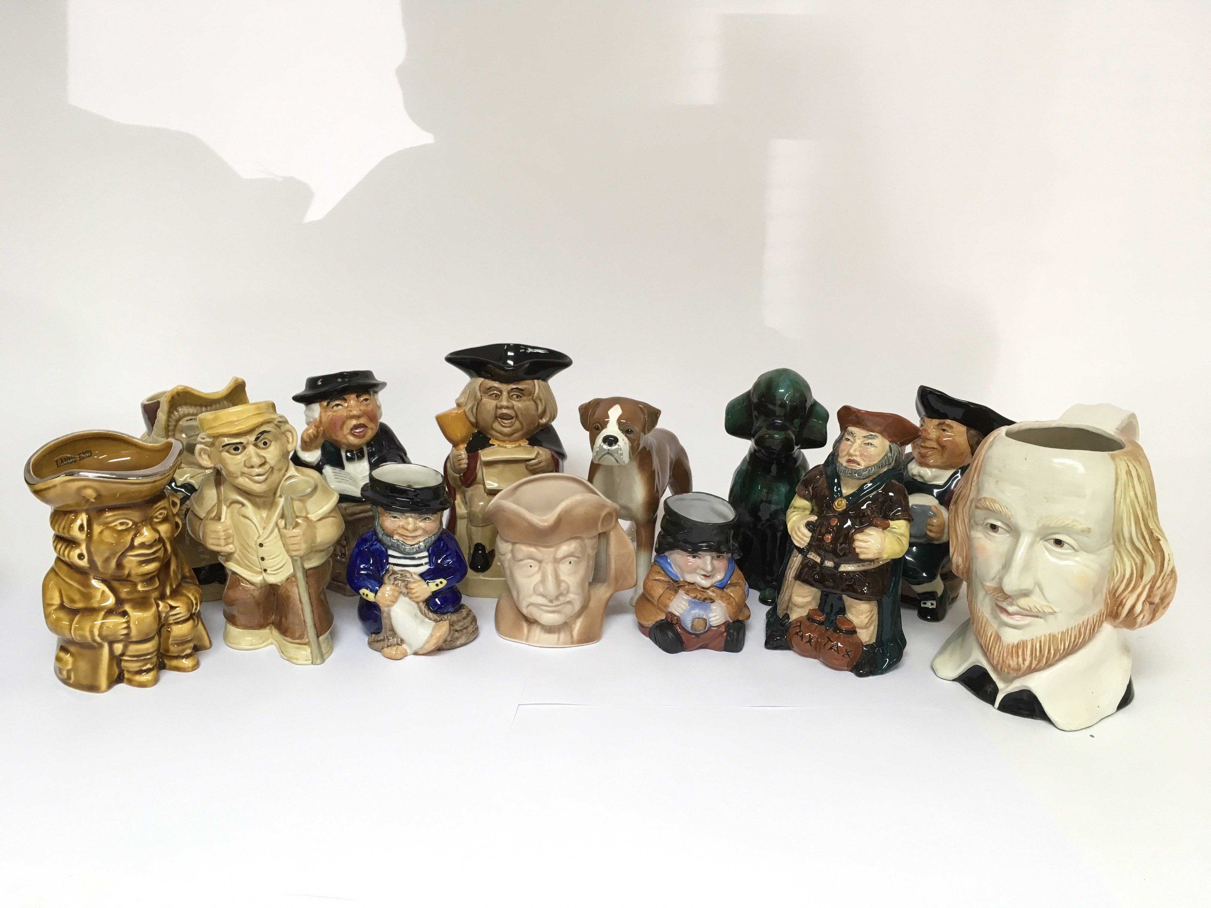 A collection of eleven ceramic caricature drinking