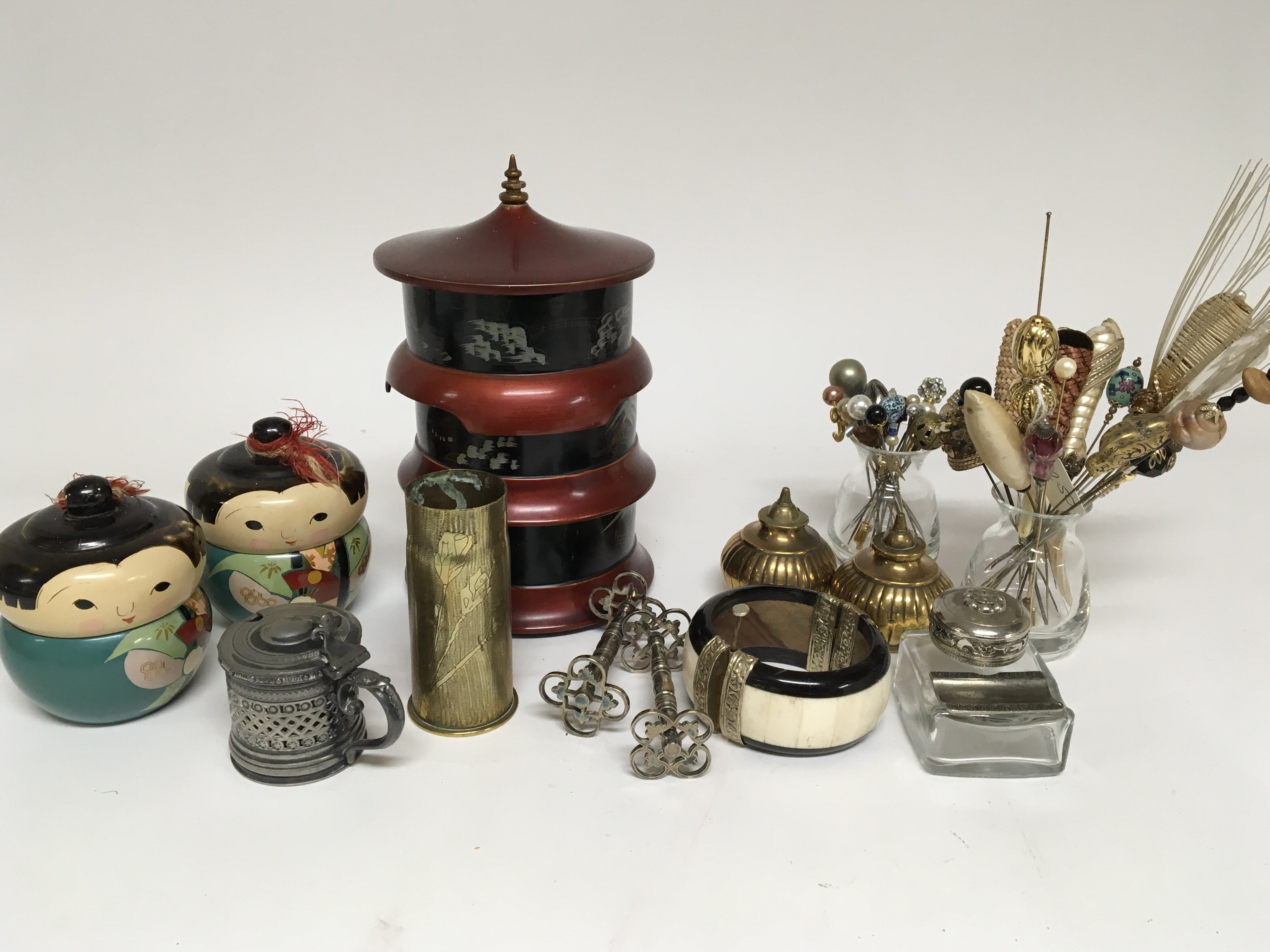 A collection of oddments comprising a bone and wood bangle hat pins laquer boxes a trench art