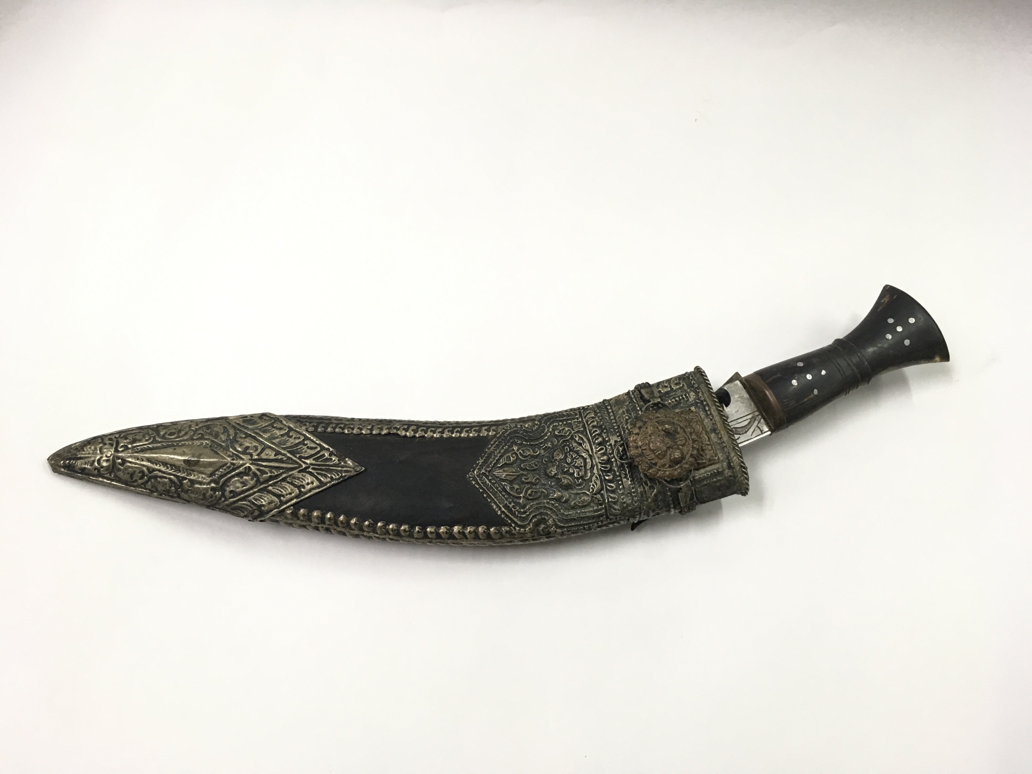 An old Gurkha kukri in leather sheath with metal w