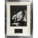 A framed and glazed photograph of Lauren Bacall wi