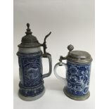 Two German pewter lidded steins, one with relief d