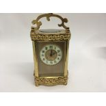 A French brass case carriage clock with visible escapement the dial with Arabic numerals