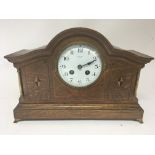 An inlaid oak mantel clock with brass pillars. French movement striking on a gong. Enamel dial maker