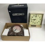 A boxed unused Seiko mantle clock and a Bell's whisky adverting wall clock