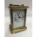 A brass cased carriage clock, approx 12cm. Comes with key.