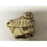 A carved Japanese late 19th Century Netsuke. In the form of a male figure.