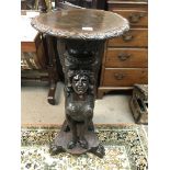 A large carved jardiniere stand of mythical form the circular with circular top and carved base with