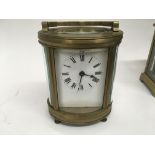 A French brass carriage clock of oval form visible escapement white dial with Roman numerals