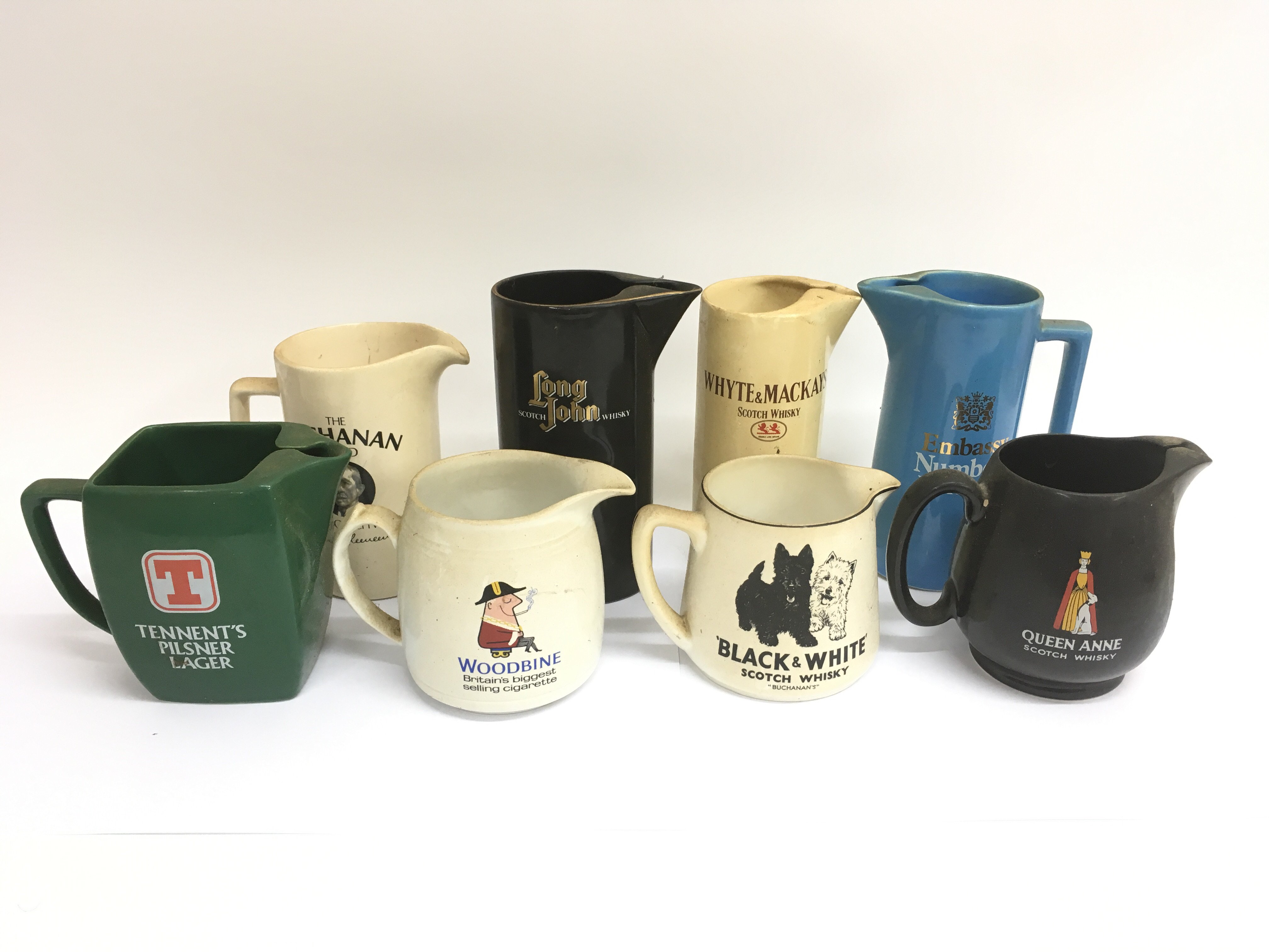 A collection of mostly breweriania decorated ceramic jugs, including a Black & White scotch whisky