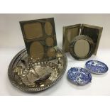 A circular silver photo frame, silver plate and two blue and white dishes.