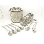 Two silver topped cut glass tidy jars alongside a cased set of silver spoons and tongs hallmarked