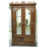 A carved Victorian/Edwardian walnut wardrobe with twin bevelled mirror doors and two drawers,