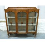 An Edwardian inlaid mahogany glazed breakfront cabinet raised on cabriole legs,