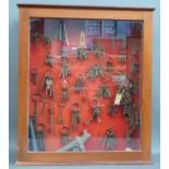 A mahogany display cabinet containing antique and vintage keys, bird or duck call, corkscrews etc,