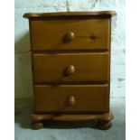 A pine bedside chest of three drawers,