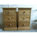A pair of pine bedside chests of three drawers,