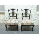 Two nursing or salon chairs raised on cabriole legs and ceramic castors