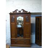 A late 19thC walnut mirror door wardrobe with drawer below,
