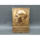 A German brass or bronze plaque of Adolf Hitler with motto below,