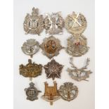 Thirteen various military cap badges to include machine gun guards, Tyneside Scottish,