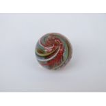 A very large handmade glass marble with red, yellow,