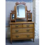 A satinwood Art Nouveau dressing table with triple bevelled mirror and brass stylised handles,