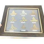 A display of nine Royal Artillery badges including Singapore, Hon Artillery Company,