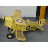 A child's pedal car in the form of a vintage biplane