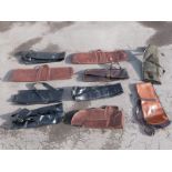 Ten various gun slips / cases, some leather and some padded.