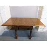 An oak extending dining table with fold over top and barley twist legs, min L72, max 144, W84,