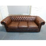 A Chesterfield brown leather two seater sofa