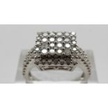 A 9ct white gold ring set with round cut diamonds in a square setting, size O, 4.