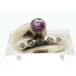 An 18ct white gold ring set with a pink sapphire and diamonds, size L/M, 6.